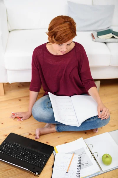 Student studia jej lekcje w salonie — Zdjęcie stockowe