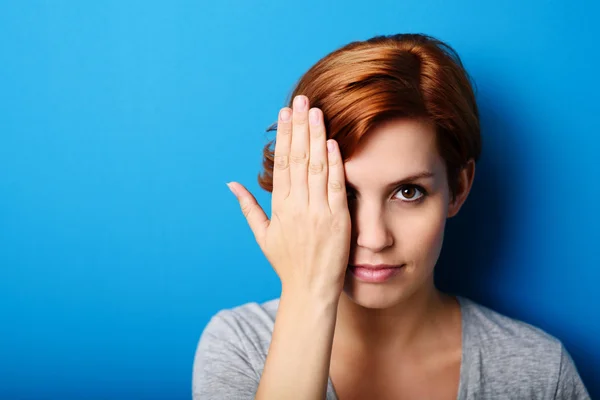 Donna che copre mezza faccia con la mano — Foto Stock