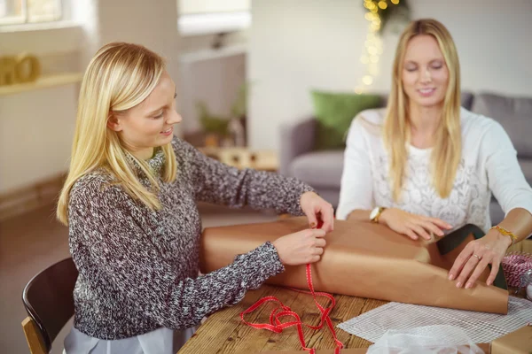 Zwei glückliche Frauen Geschenke verpacken — Stockfoto