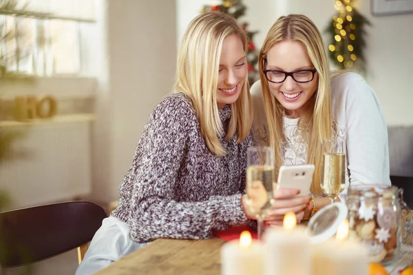 Sisters looking at her smartphone — Stock Photo, Image