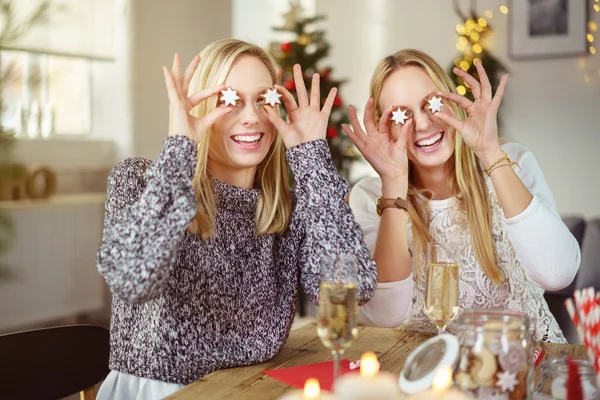 Sisters have fun putting christmas cookies on the eyes — Stock Photo, Image