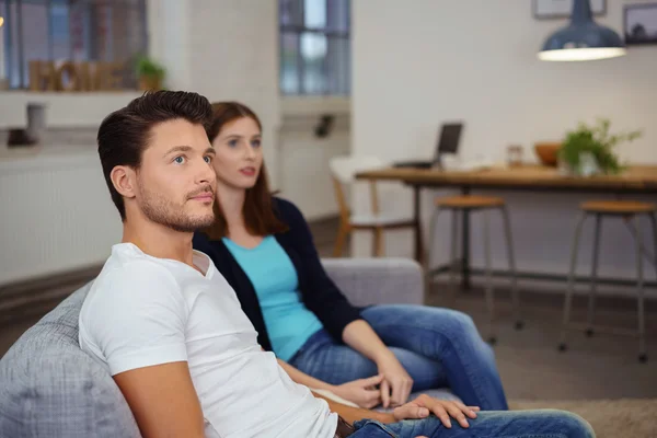 Thoughtful couple sitting on the sofa — Stock Photo, Image