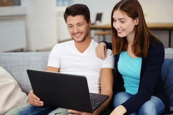 Pareja joven compartiendo cuaderno — Foto de Stock