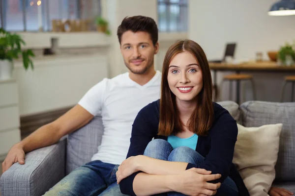 Junges Paar sitzt entspannt auf dem Sofa — Stockfoto