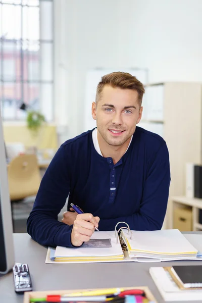 Smiling young businessman writing notes — Stock Photo, Image