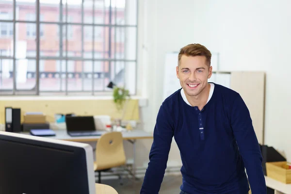 事務所で机に立っている笑顔の実業家 — ストック写真