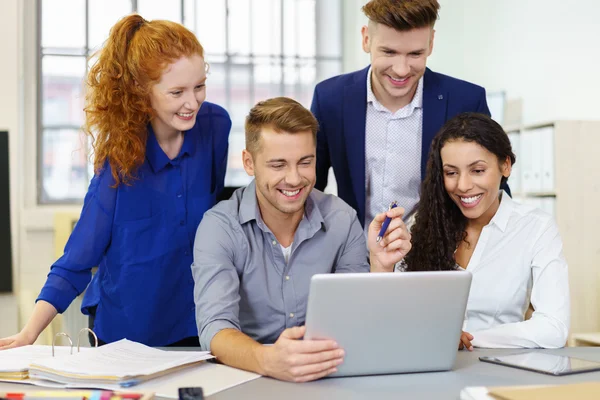 Equipe olhando para notebook — Fotografia de Stock