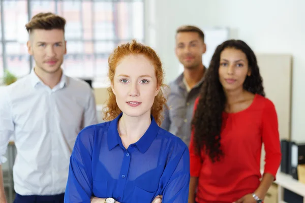 Empresária com equipe em segundo plano — Fotografia de Stock