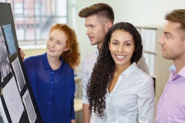 Ufficio donna sorride a fotocamera mentre brainstorming — Foto Stock