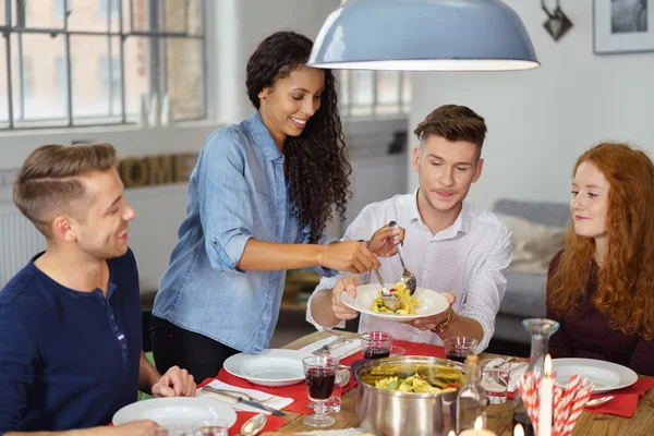 Woman Dishing Up Main Course to Friends — Stock fotografie