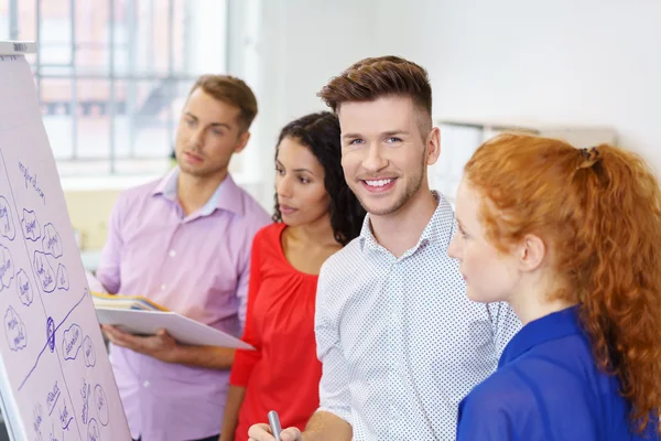 Geschäftsmann lächelt beim Brainstorming in die Kamera — Stockfoto