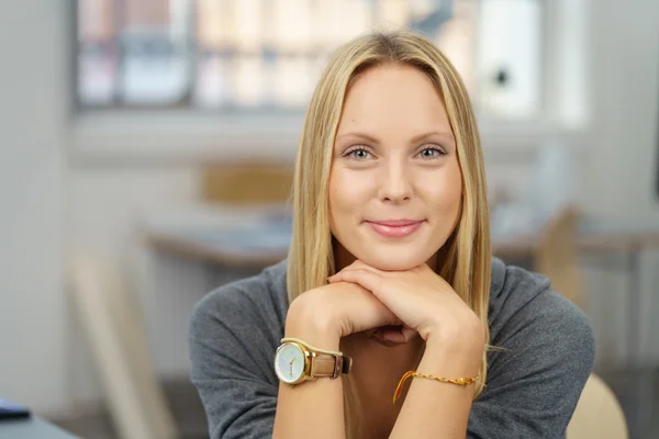 Jolie femme de bureau penchant son menton sur ses mains — Photo