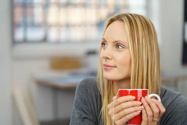 Fille de bureau réfléchie tenant une tasse de thé rouge — Photo