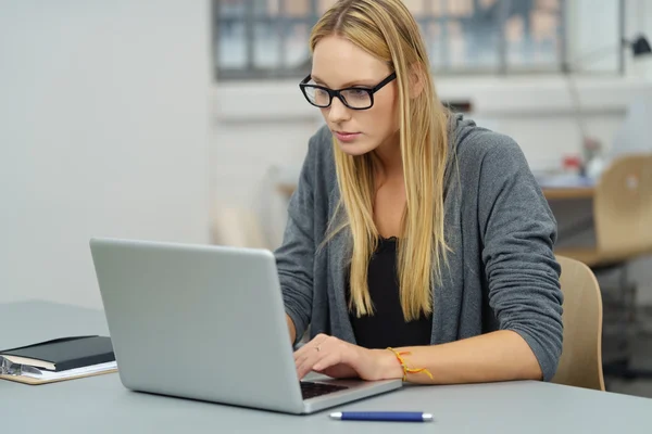 Ufficio donna lavoro su il suo computer portatile a il suo scrivania — Foto Stock