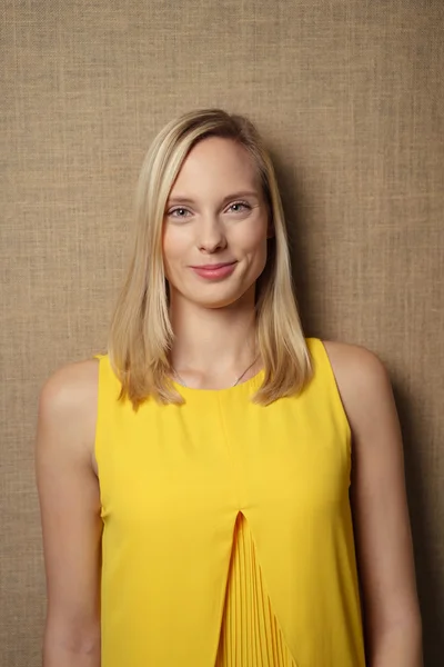 Stylish Woman in Yellow Shirt Against Brown Wall — Stockfoto