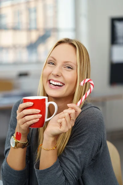 Glückliche Bürofrau mit einer Tasse und Süßigkeiten — Stockfoto