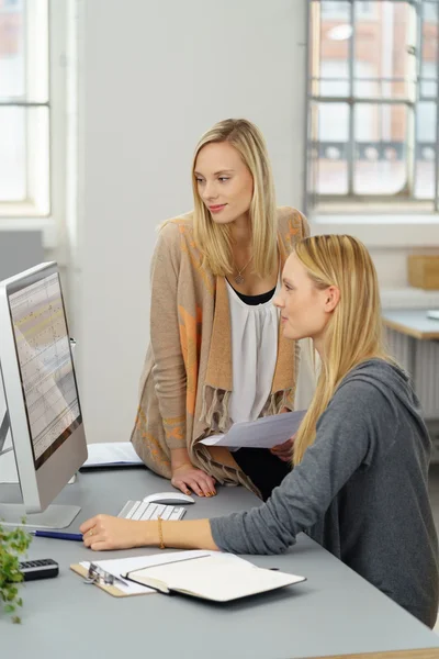 Bürofrauen lesen Daten auf Computerbildschirm — Stockfoto