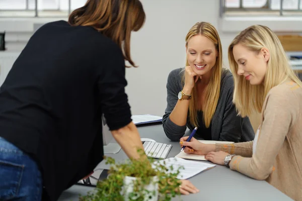 Trois femmes de bureau qui travaillent ensemble sur un document — Photo