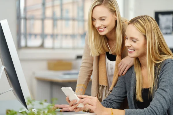 Zwei Frauen beim Vorlesen einer Telefonnachricht — Stockfoto