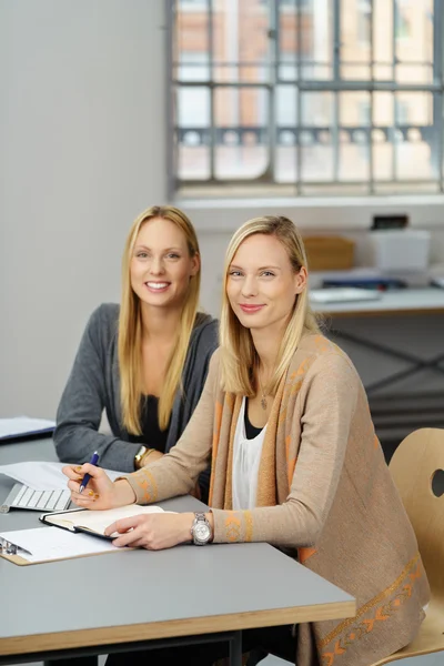 Due belle donne in ufficio sedute a tavola — Foto Stock