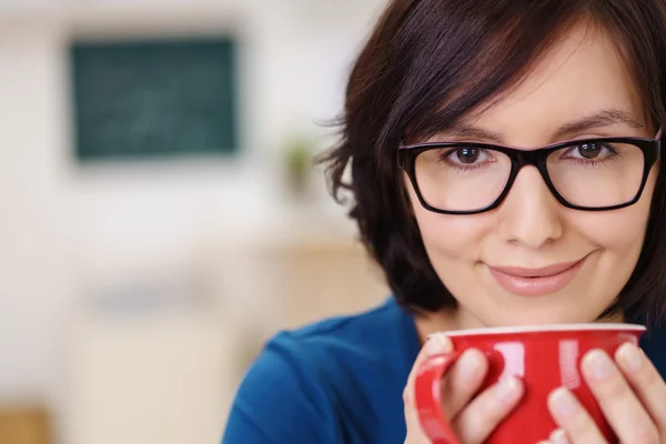 Mujer bonita sonriente sosteniendo una taza de café — Foto de Stock