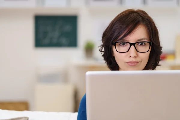 Geschäftsfrau mit Laptop blickt in die Kamera — Stockfoto