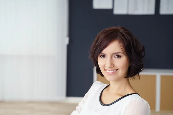 Junge hübsche Bürofrau lächelt in die Kamera — Stockfoto