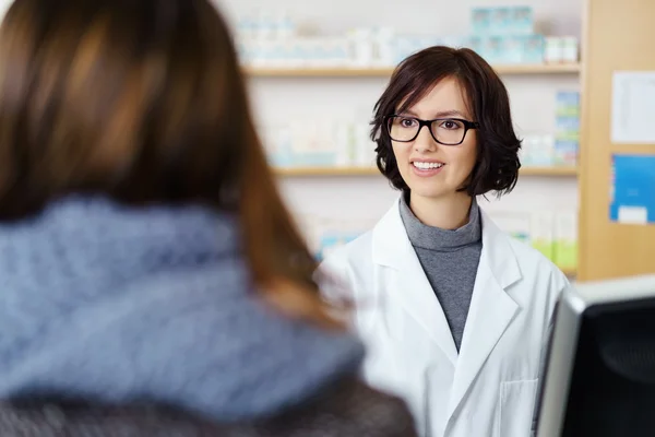 Farmacêutico a falar com um cliente no balcão — Fotografia de Stock