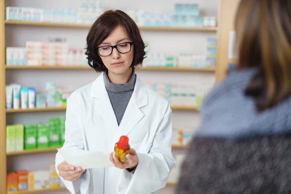 Farmacéutico leyendo la prescripción en el mostrador —  Fotos de Stock