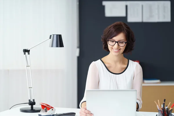 Zufriedene Geschäftsfrau arbeitet am Laptop am Schreibtisch — Stockfoto