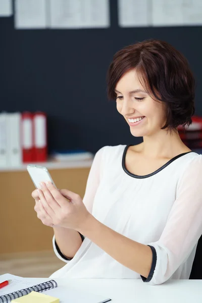 Felice ufficio donna occupato con il suo cellulare — Foto Stock