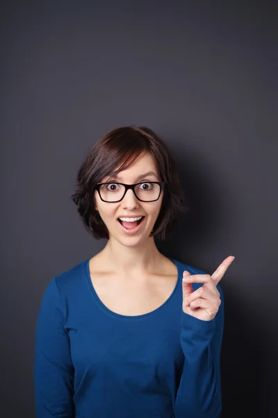 Geschokt Woman wijzend weg tegen grijze muur — Stockfoto