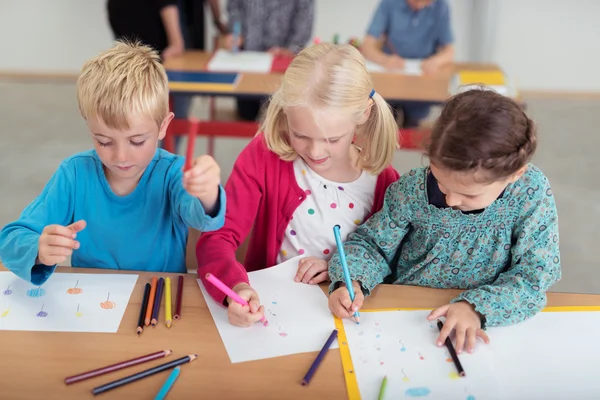 Drie jonge kinderen in kleuterschool kunst klasse — Stockfoto