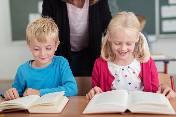 Dwie uśmiechnięte szczęśliwe małe dzieci w klasie — Zdjęcie stockowe