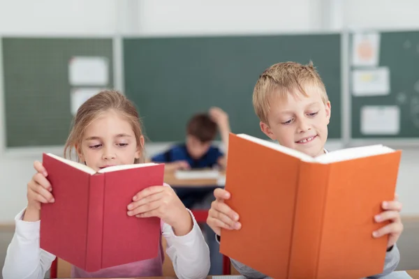 Två unga skolbarn läsning från läroböcker — Stockfoto