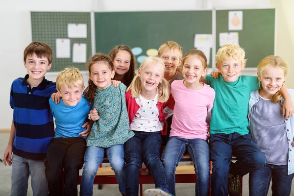 Kinderen in hun klas glimlachen naar de camera — Stockfoto