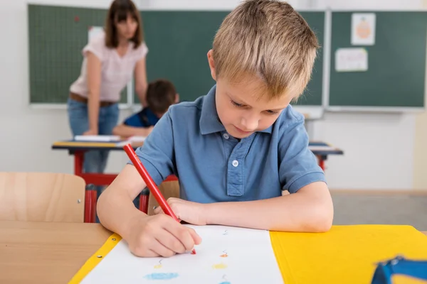 Söt pojke besvara Test inuti klassrummet — Stockfoto