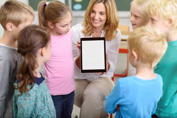 Веселый учитель обучает детей с помощью планшета — стоковое фото