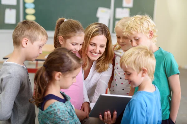 Insegnante e bambini che guardano un video su tablet — Foto Stock