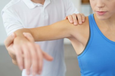 Physical Therapist Examines the Shoulder of Woman clipart