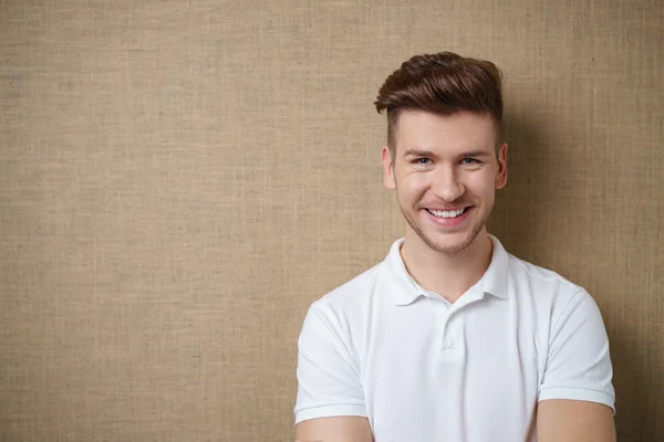 Hombre sonriente contra la pared marrón con espacio de copia — Foto de Stock