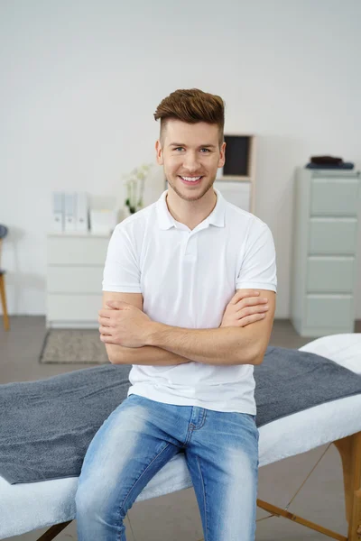 Guapo terapeuta masculino sentado en la cama de la terapia — Foto de Stock