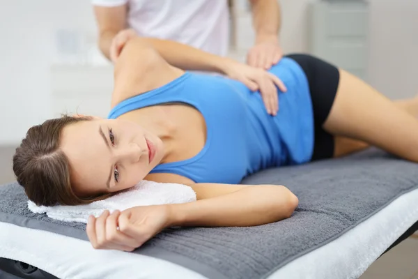 Jonge vrouw liggend op haar kant terwijl therapie — Stockfoto