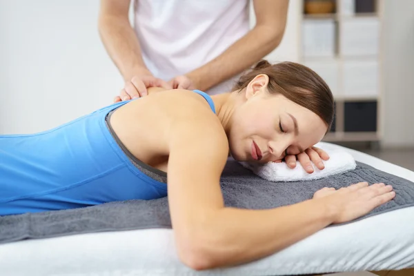Mujer teniendo un masaje en su espalda superior lesionada —  Fotos de Stock