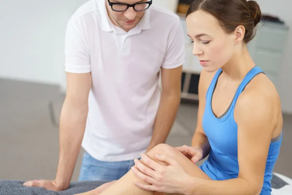 Frau zeigt ihrem Physiotherapeuten ihr Knie — Stockfoto