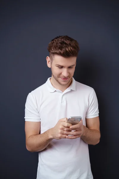 Joven guapo buscando mensajes —  Fotos de Stock