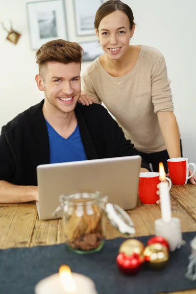 Jovem casal feliz com laptop em casa — Fotografia de Stock
