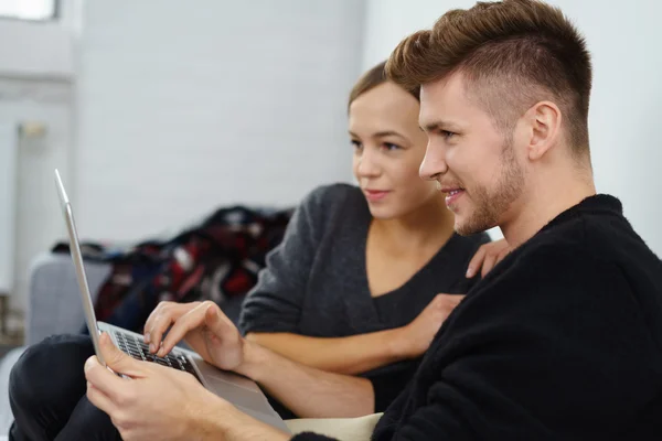 Couple relaxing at home looking at notebook — Stock Photo, Image