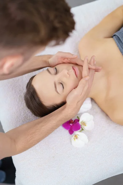 Jeune femme bénéficiant d'un massage de la tête les yeux fermés — Photo