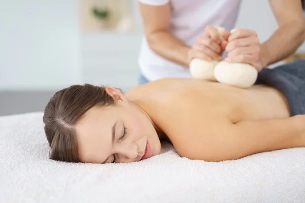 Vrouw genieten van een schoonheidsbehandeling met kruiden kompressen — Stockfoto